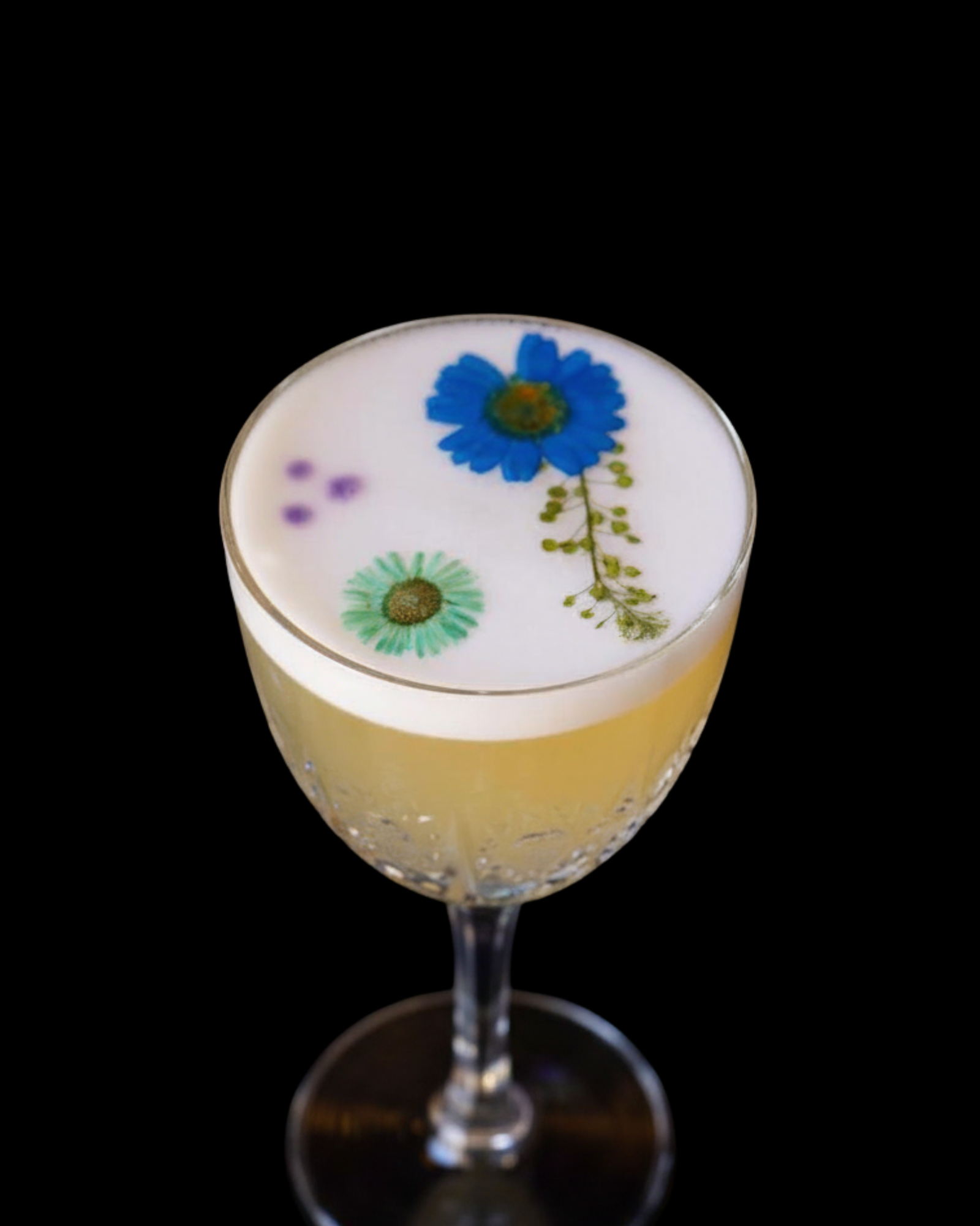 Citrus cocktail with flavor-neutral foam and blue flower garnish